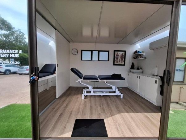 Inside the Pod: treatment bed, cabinetry and wall charts